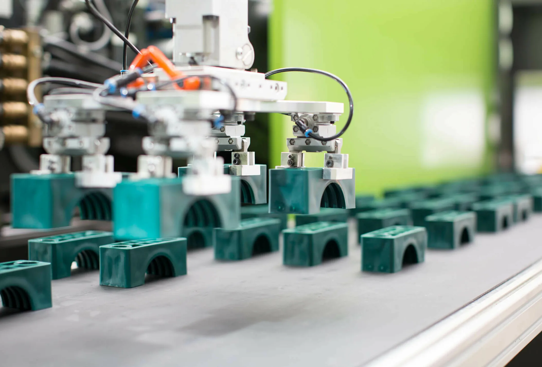 viele grüne kleine Teile auf einem Laufband, Herstellung von Verschlauchungskomponenten