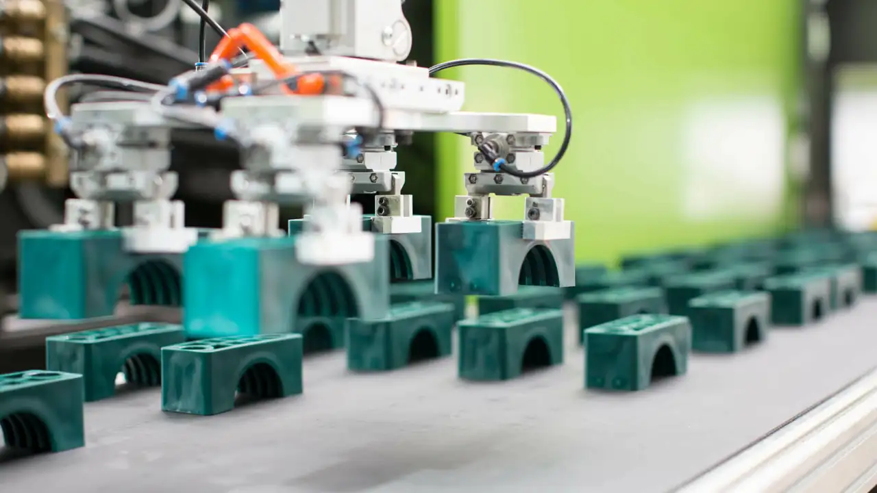 viele grüne kleine Teile auf einem Laufband, Herstellung von Verschlauchungskomponenten