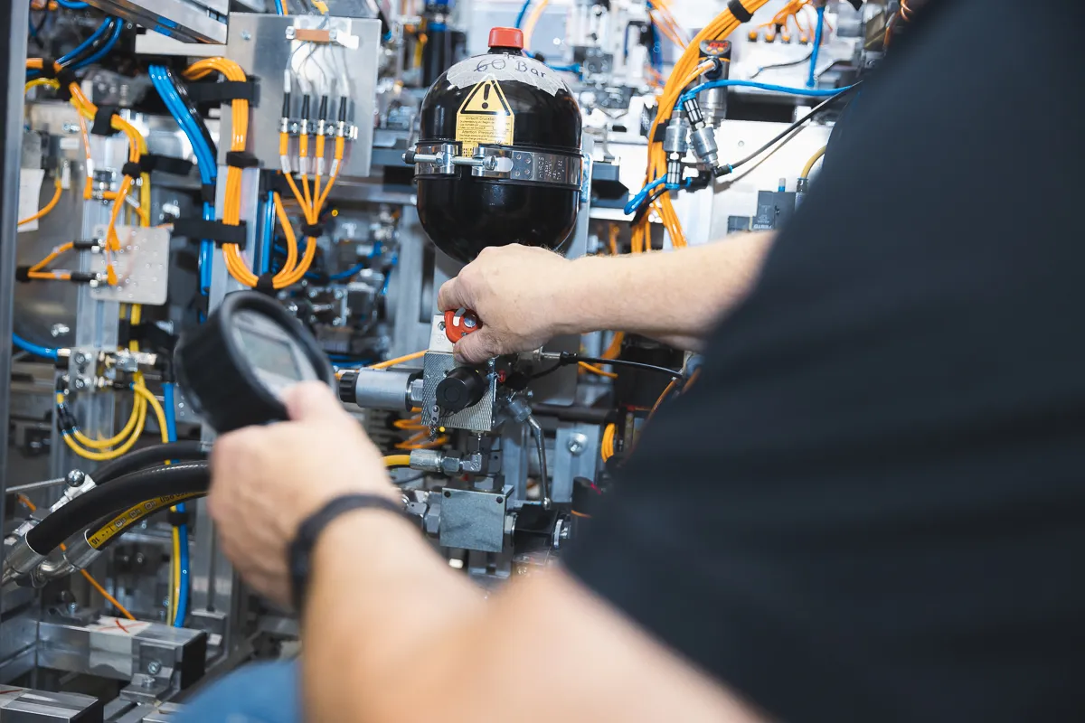 Mann überprüft Maschine mit Messgerät