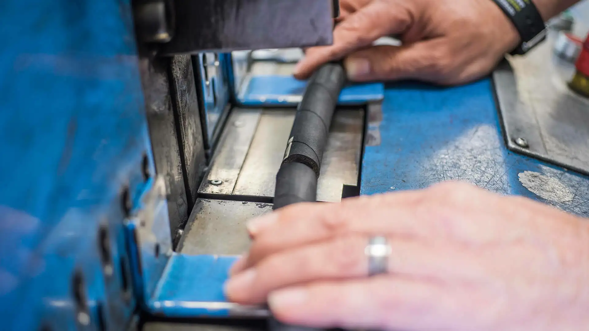 Nahaufnahme von zwei Händen, welche Schlauch schneidet