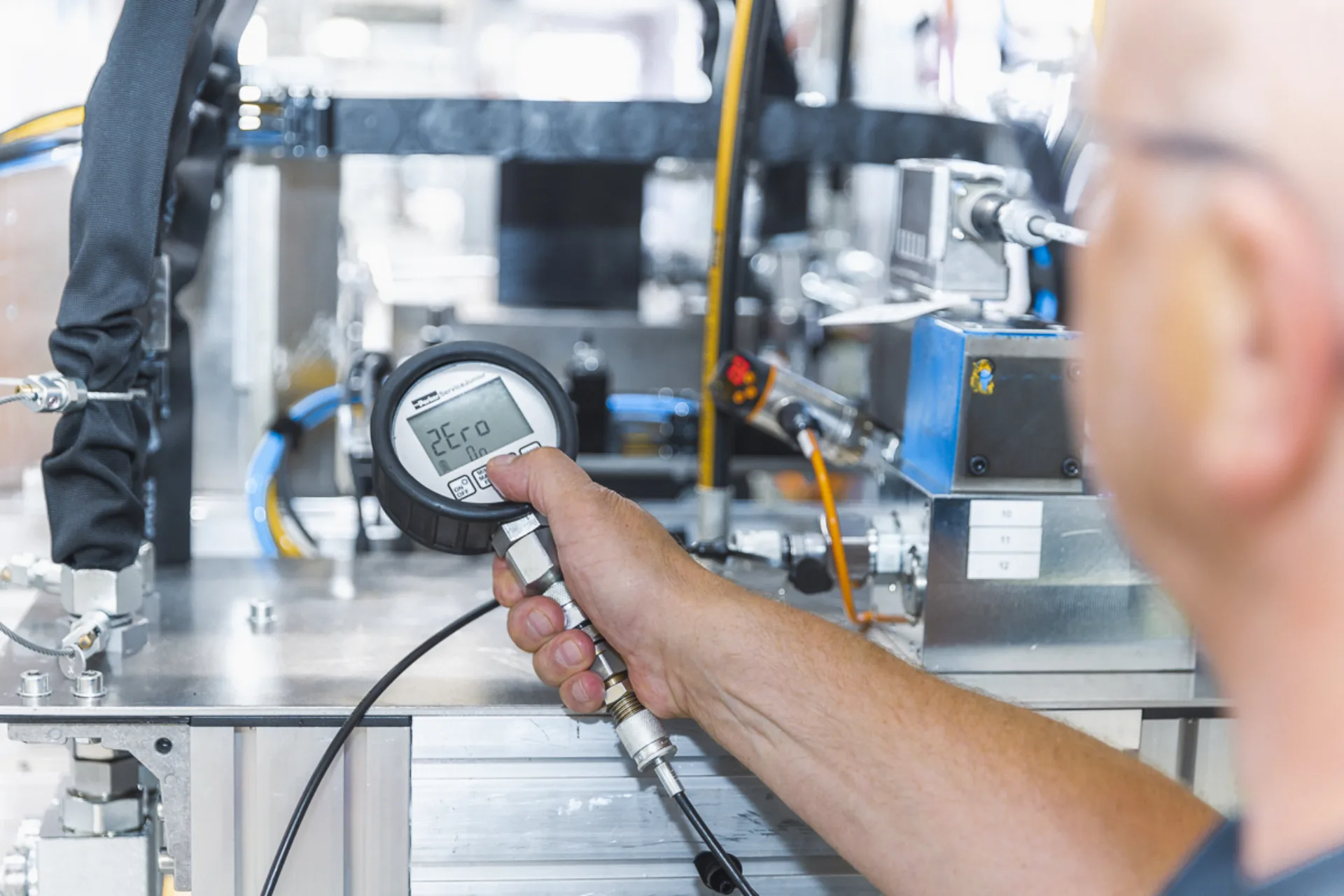 Mann hält Messgerät vor Industriemaschine, Ergebnis: 2Ero