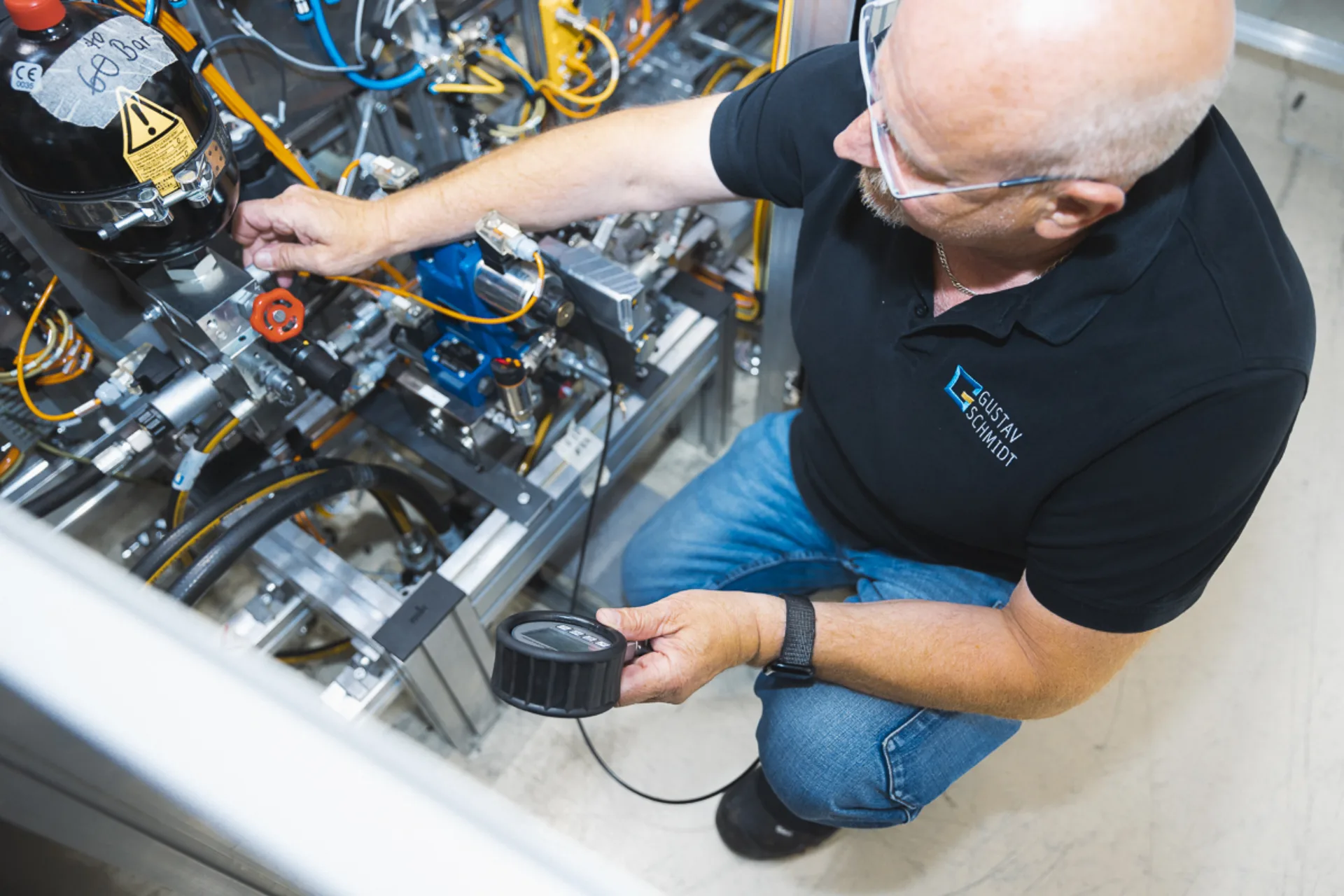 Mann überprüft eine Maschine mit einem Messgerät