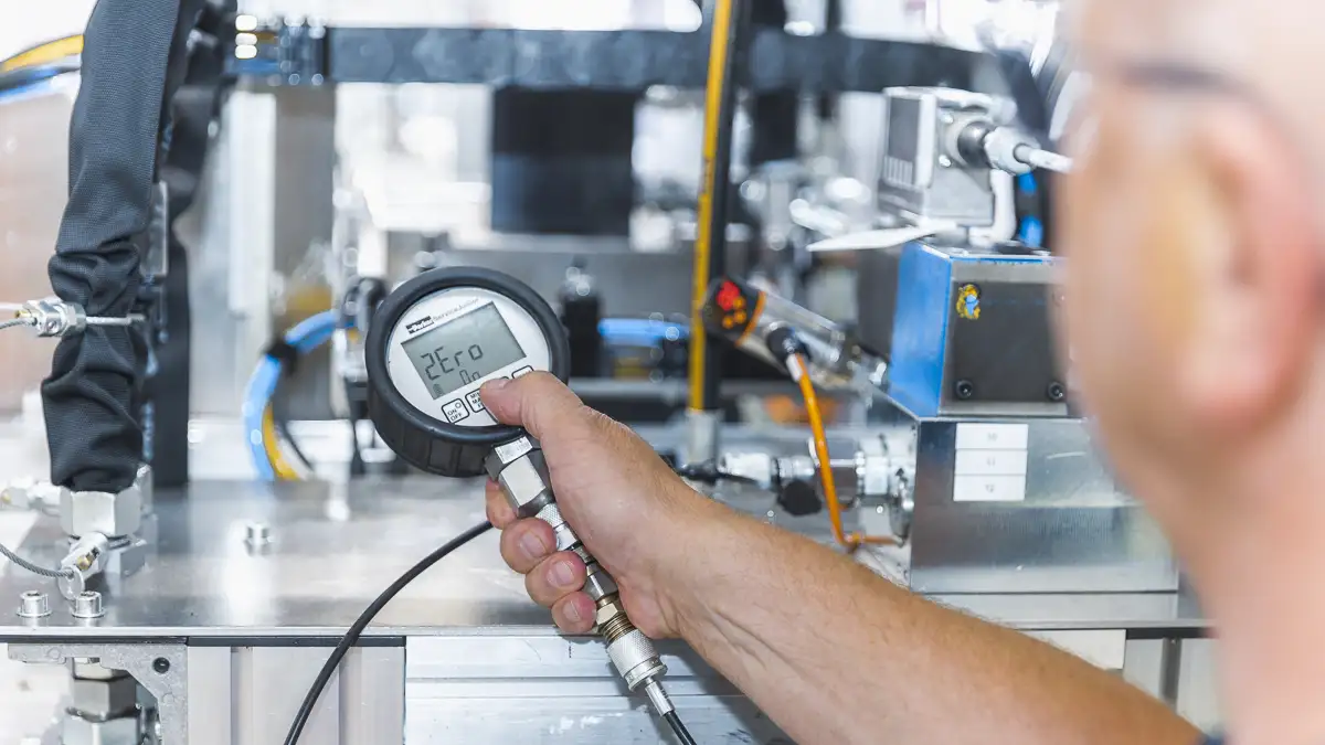 Mann hält Messgerät vor Industriemaschine, Ergebnis: 2Ero