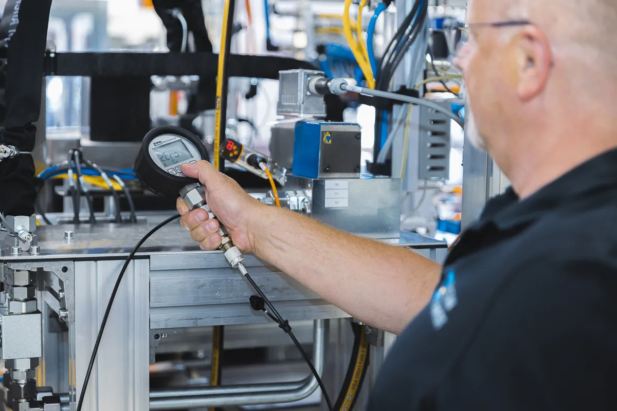 Mann misst Schlauchdruck mit Messmaschine
